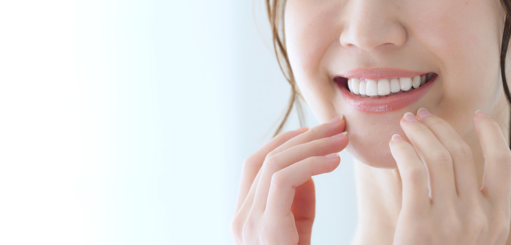 ผู้หญิงยิ้มโชว์ฟันขาวจากการฟอกสีฟัน